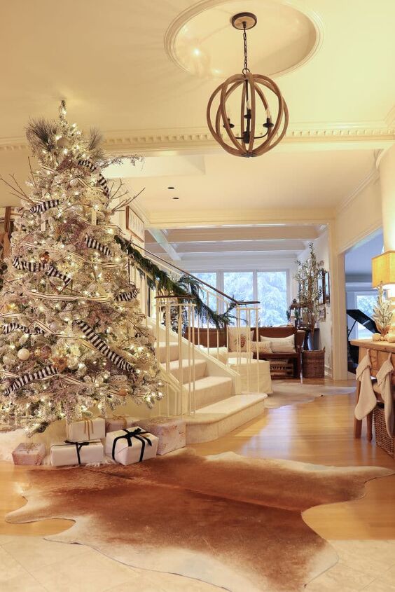 6 easy ways to achieve an irresistibly festive white christmas tree, Artificial flocked tree is elegant in beautiful foyer next to staircase