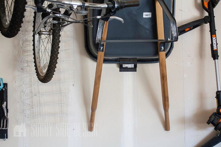 the best tips to an organized and functional garage, Wheel barrow is mounted to hook and stored on the wall with a wheel barrow hook
