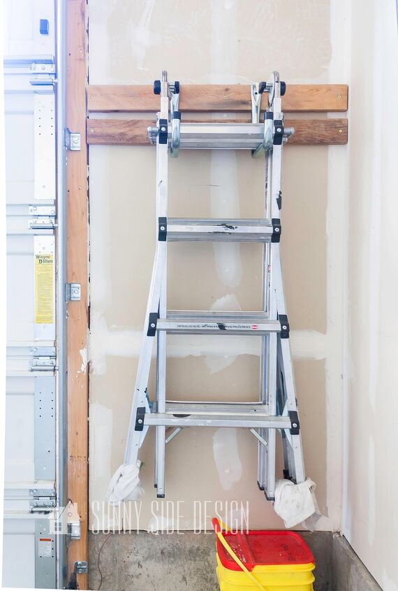 the best tips to an organized and functional garage, Large hooks are mounted to a 2x4 vboard to hang the ladder on the garage wall