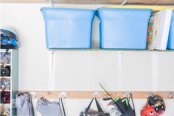 the best tips to an organized and functional garage, Labeled storage bins are placed on shelves mounted to garage wall