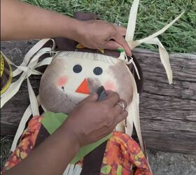 Adding wood stain to the scarecrow