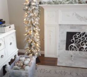Box of gold and white ball ornaments by the tree
