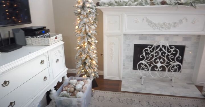 Box of gold and white ball ornaments by the tree